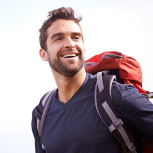 man hiking and smiling