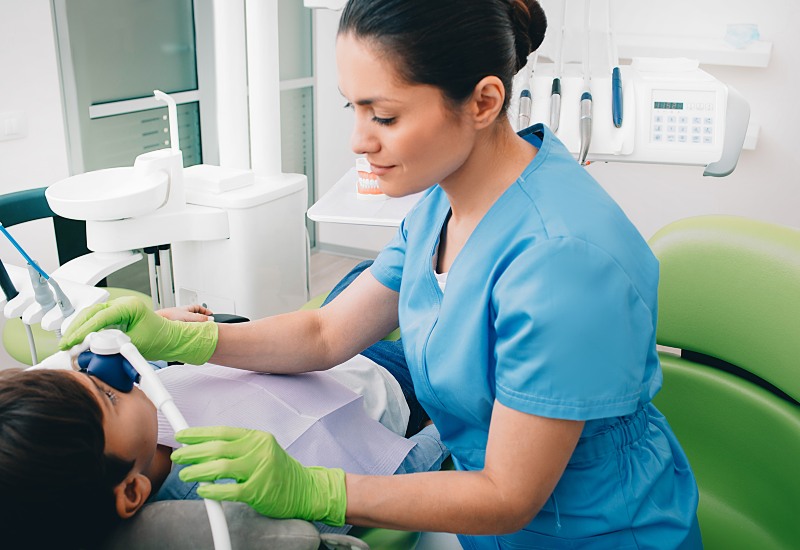 A dental expert administering sedation via nasal mask to a patient in a clinic in Millersburg, OH