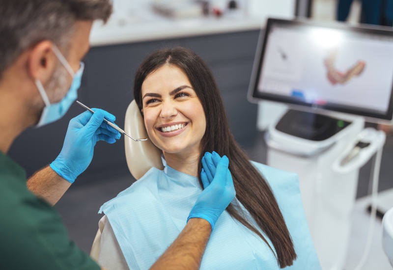 A dentist with a smiling patient showing a 3D scan during a checkup at the clinic in Millersburg, OH
