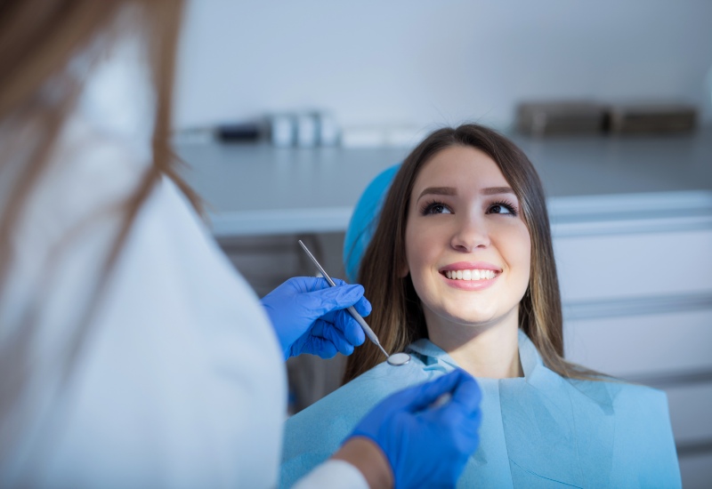 A dentist discusses the impact of hormonal changes on oral health with a patient in Millersburg, OH