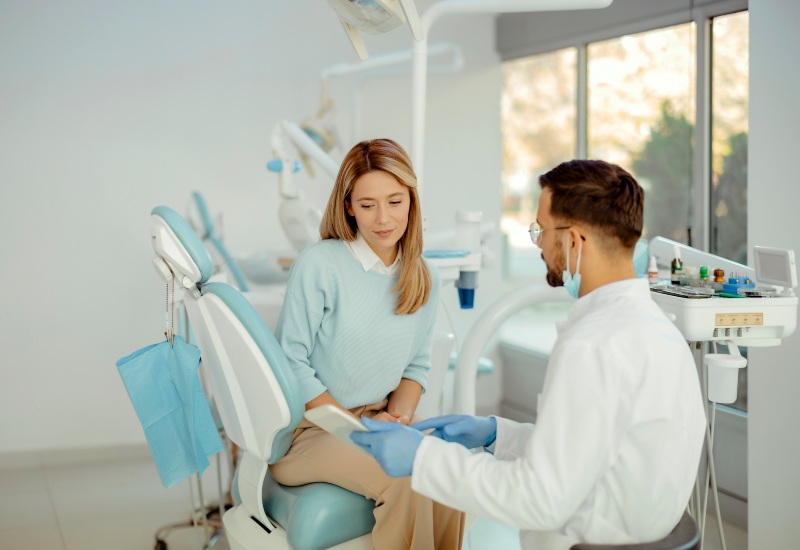 A dentist explaining soft teeth prevention to a patient using a tablet in Millersburg, OH