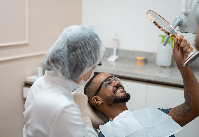 A happy patient seeing results with a dentist after a cosmetic dental treatment in Millersburg, OH