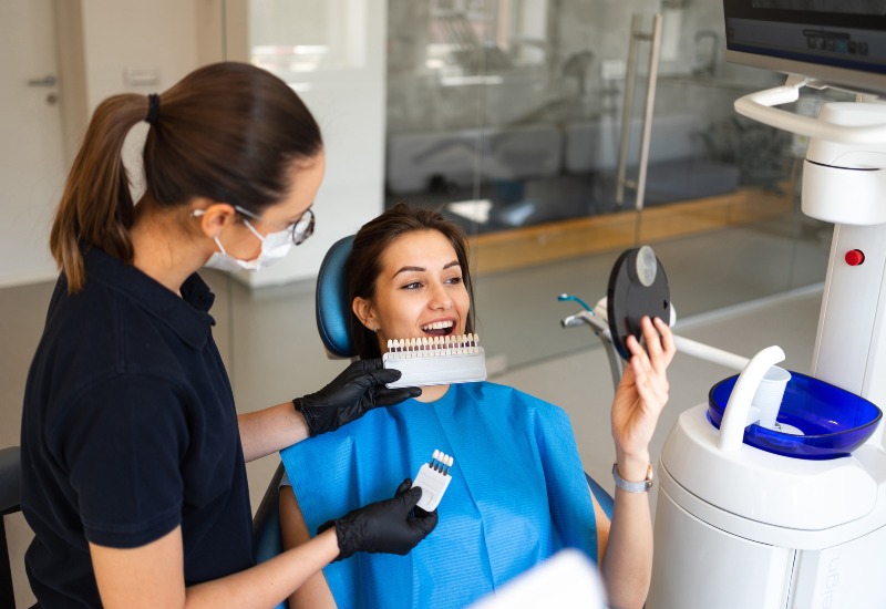 A dentist and patient selecting tooth shade for dental veneers treatment in Millersburg, OH